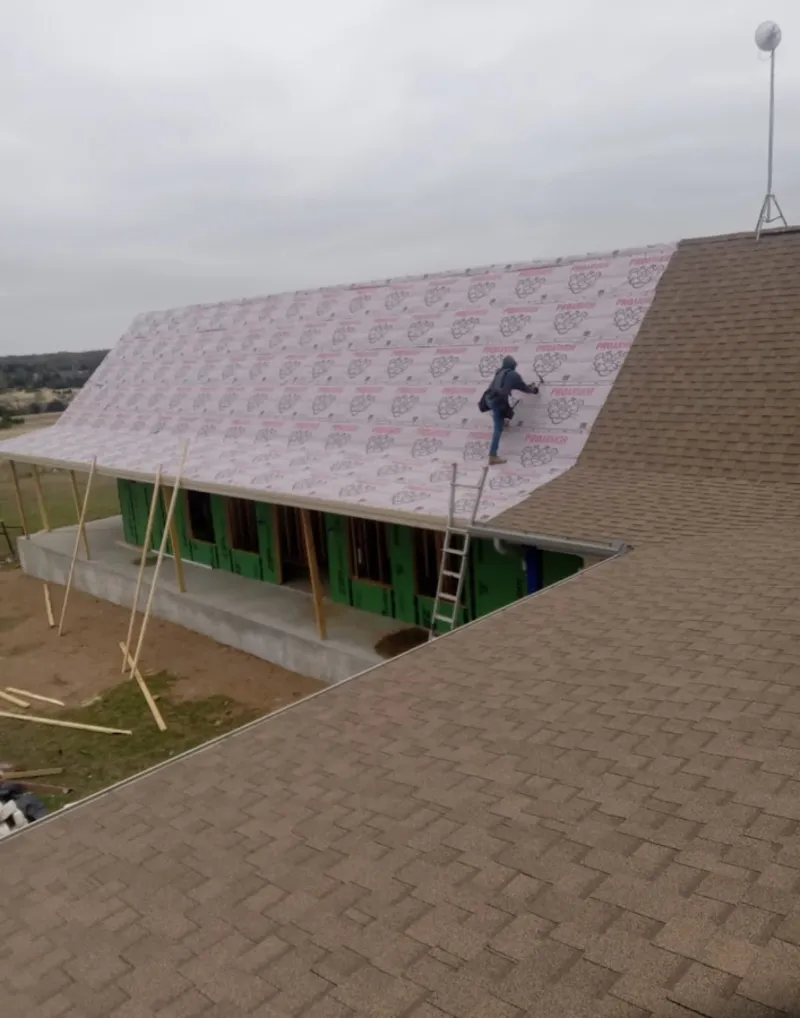 Worker preparing underlayment for a metal roof installation in Kendale Lakes